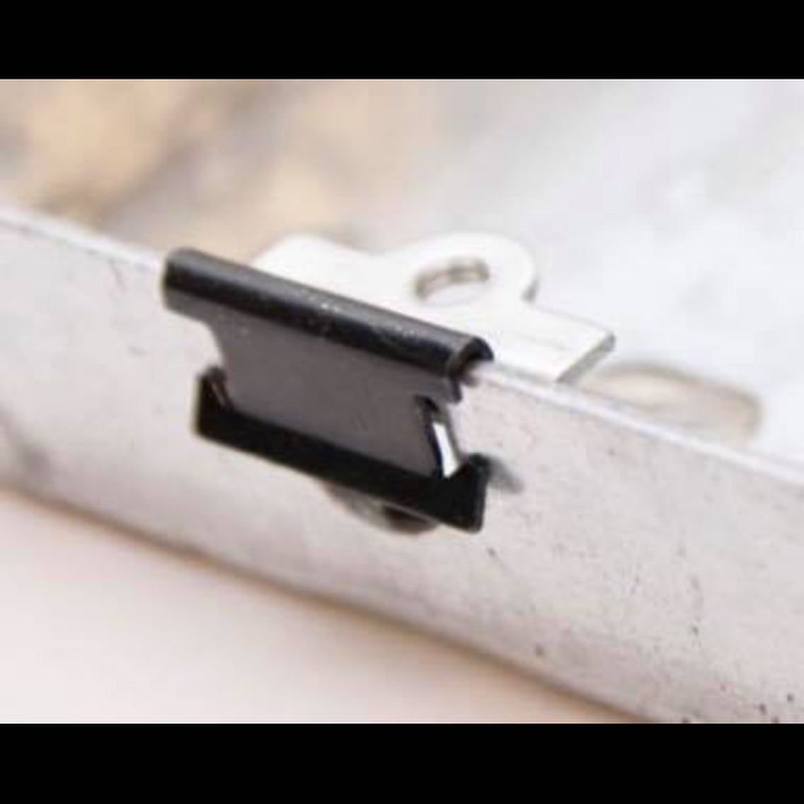 Back box repair clip pushed onto a metal electrical back box to replace a broken lug or thread – image 2